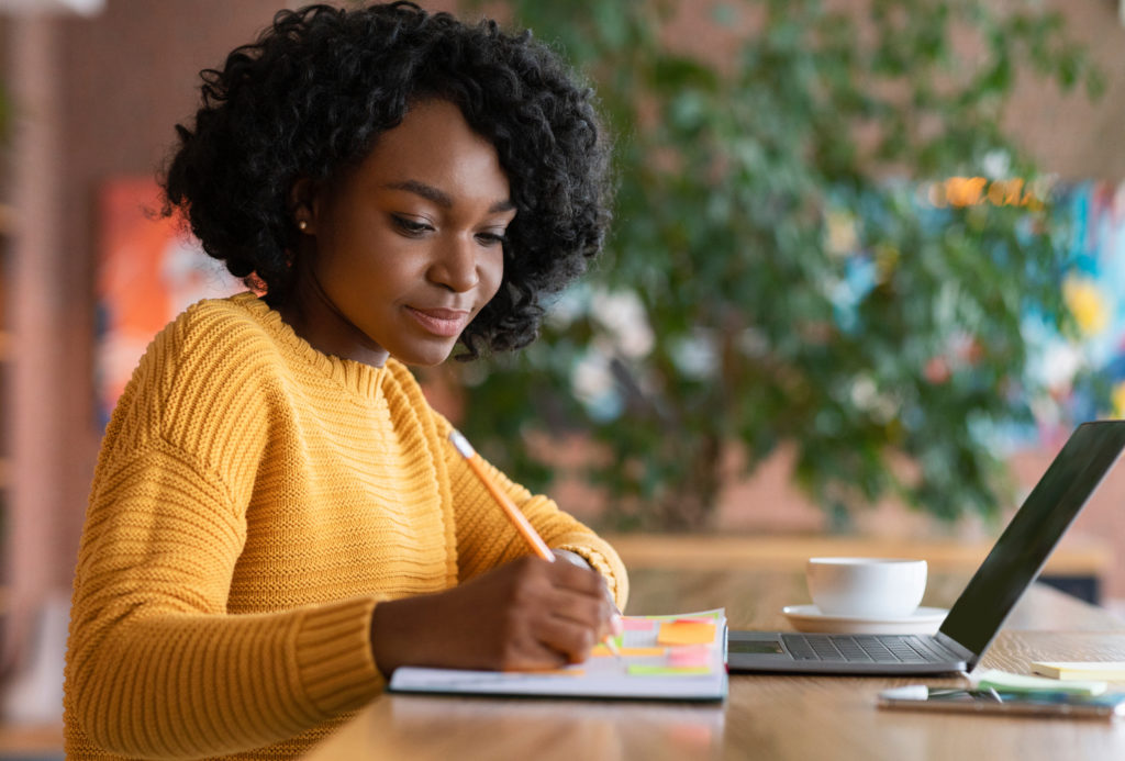 Femme afro engagée utilisant un ordinateur portable pour la gestion des heures de délégation CSE