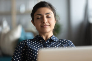 Responsable RH détendue devant son ordinateur, illustrant les bénéfices d’un logiciel de gestion des bons de délégation.